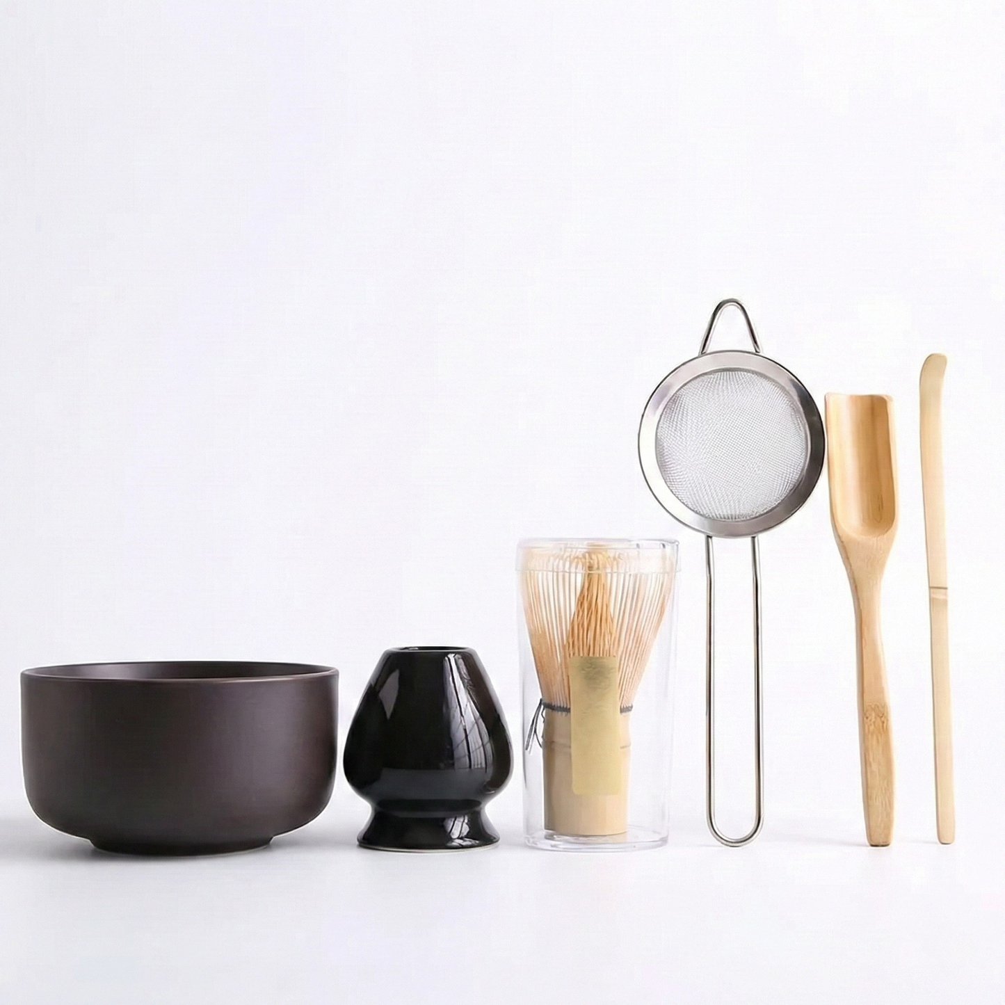 Kit de préparation matcha au design épuré et moderne, comprenant un bol brun chocolat mat lisse et un porte-fouet noir brillant pour une esthétique sobre.