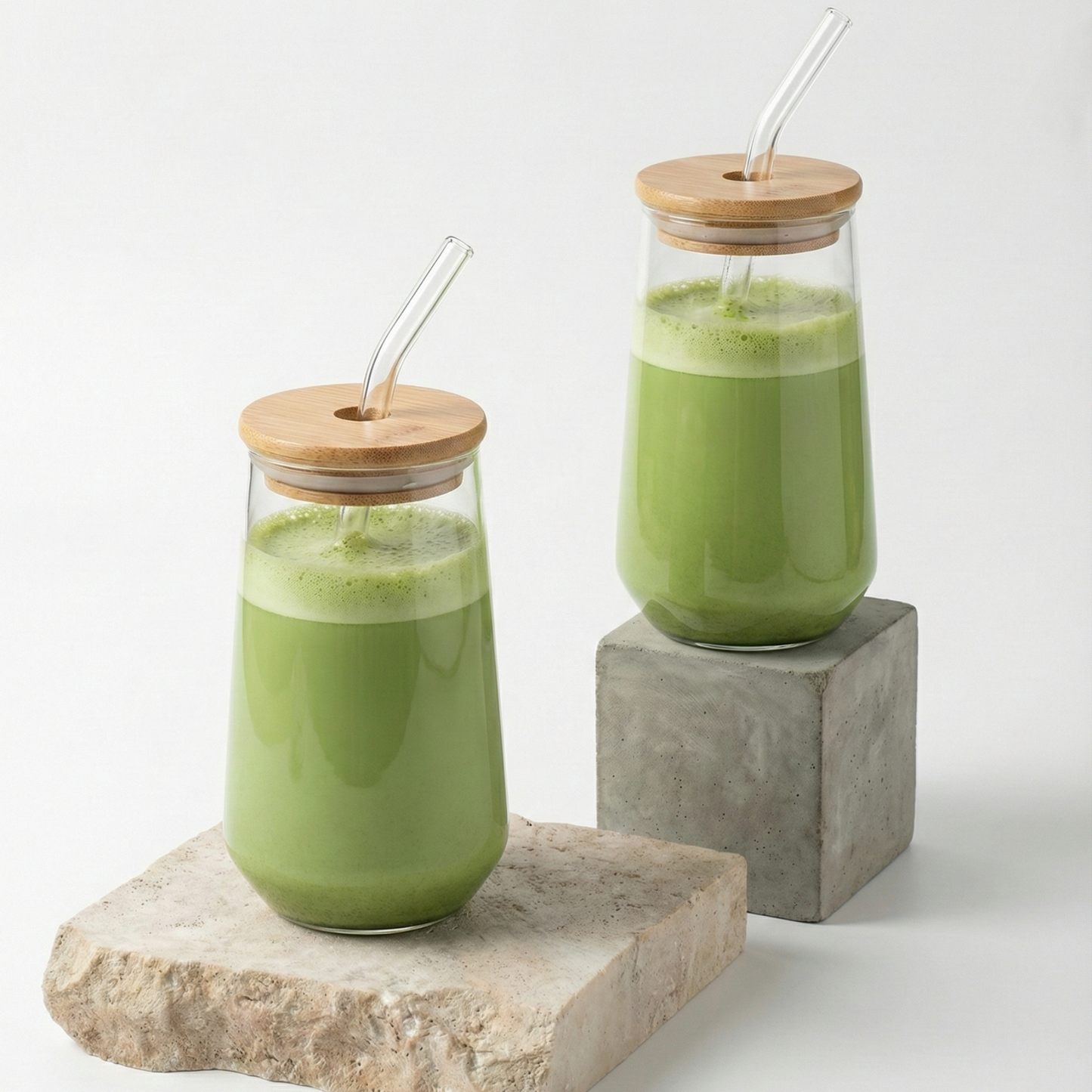Deux gobelets en verre strié (modèle Mistral) remplis de Iced Matcha Latte vert, présentés avec leurs couvercles en bambou et pailles en verre, illustrant la grande contenance de 600ml idéale pour l'été.