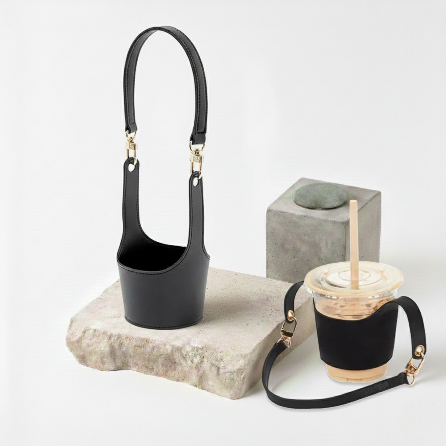 Manchon de transport en cuir vegan noir profond présenté avec un gobelet de café glacé, offrant un look urbain chic et une prise en main sécurisée anti-glisse.